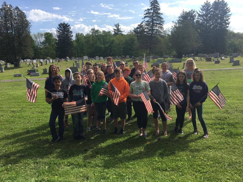 Joann Yungwirth's class putting flags on graves at Wellsboro Cemetery. Memorial Day 2019.